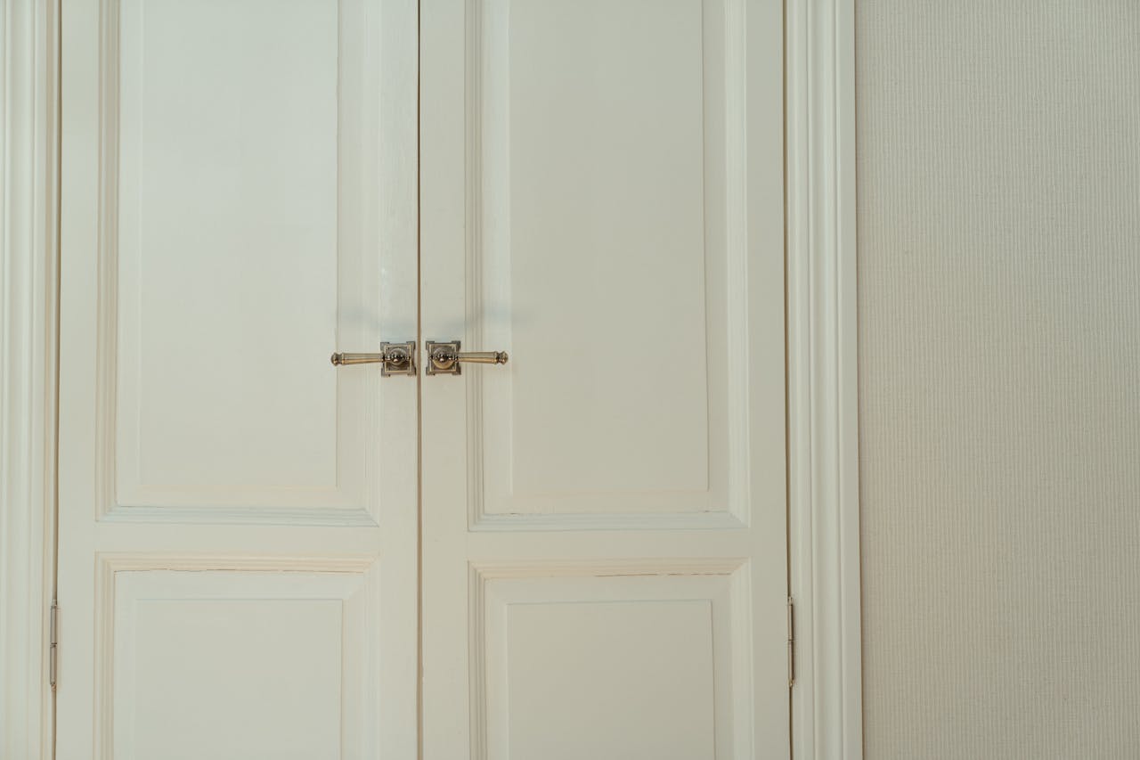 about-01 Elegant white double doors with locks, offering a stylish and secure home interior solution.